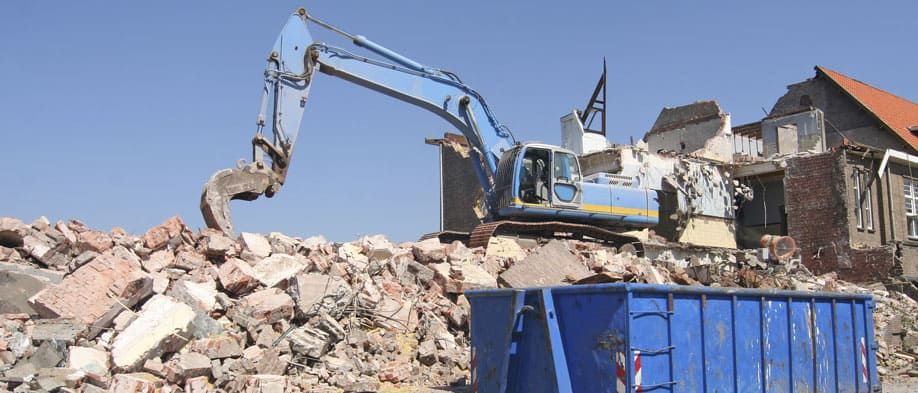 Excavadora moviendo escombros de demolición